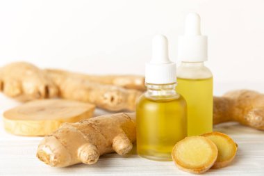 Doku arka planında zencefil yağı var. Taze zencefil dilimleri. Esans, serum, yağ. Alternatif tıp. Beden eğitimi. Sağlık ve güzellik konsepti. Mesaj için yer. Boşluğu kopyala.