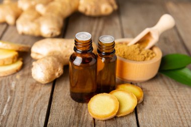 Doku arka planında zencefil yağı var. Taze zencefil dilimleri. Esans, serum, yağ. Alternatif tıp. Beden eğitimi. Sağlık ve güzellik konsepti. Mesaj için yer. Boşluğu kopyala.