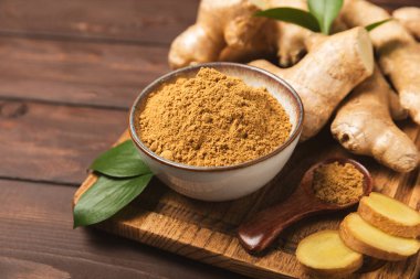 Ahşap arka planda taze zencefil. Kuru zencefil. Ballı ve limonlu zencefil dilimi. Zencefil kökü. Geleneksel alternatif tıp, bağışıklık için çay. Baharat ve baharat konsepti. Boşluğu kopyala.