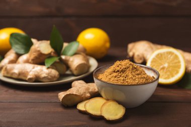 Ahşap arka planda taze zencefil. Kuru zencefil. Ballı ve limonlu zencefil dilimi. Zencefil kökü. Geleneksel alternatif tıp, bağışıklık için çay. Baharat ve baharat konsepti. Boşluğu kopyala.