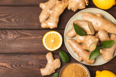 Ahşap arka planda taze zencefil. Kuru zencefil. Ballı ve limonlu zencefil dilimi. Zencefil kökü. Geleneksel alternatif tıp, bağışıklık için çay. Baharat ve baharat konsepti. Boşluğu kopyala.