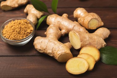 Ahşap arka planda taze zencefil. Kuru zencefil. Ballı ve limonlu zencefil dilimi. Zencefil kökü. Geleneksel alternatif tıp, bağışıklık için çay. Baharat ve baharat konsepti. Boşluğu kopyala.