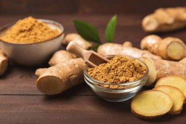 Ahşap arka planda taze zencefil. Kuru zencefil. Ballı ve limonlu zencefil dilimi. Zencefil kökü. Geleneksel alternatif tıp, bağışıklık için çay. Baharat ve baharat konsepti. Boşluğu kopyala.