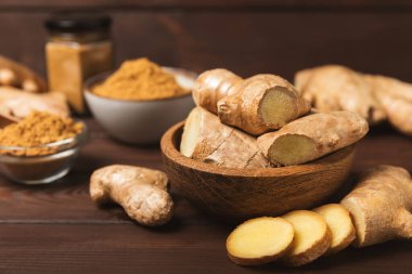 Ahşap arka planda taze zencefil. Kuru zencefil. Ballı ve limonlu zencefil dilimi. Zencefil kökü. Geleneksel alternatif tıp, bağışıklık için çay. Baharat ve baharat konsepti. Boşluğu kopyala.