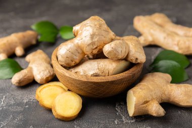 Ahşap arka planda taze zencefil. Kuru zencefil. Ballı ve limonlu zencefil dilimi. Zencefil kökü. Geleneksel alternatif tıp, bağışıklık için çay. Baharat ve baharat konsepti. Boşluğu kopyala.