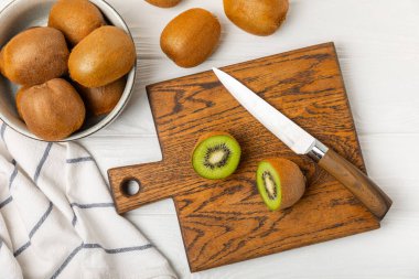 Ahşap arka planda Kivi. Masada tam meyve ve dilimler halinde yeşil kivi var. Taze sulu kivi. Tropik meyve. Organik meyve. Sağlıklı beslenme. Mesaj için yer var. Boşluğu kopyala.