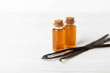 Tahta bir masanın üzerinde cam kaplama vanilya özü. Kek ve tatlı için vanilya özü. Aromatik ev yapımı vanilya özü. Kapatın. Mesajı yerleştir. Boşluğu kopyala.