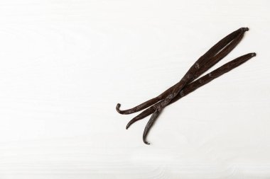 Dokulu bir arka planda vanilya kabukları. Vanilya çiçekleri ve tohumlar. Vanilyalı fasulye. Hamur işleri ve tatlılar için baharatlı baharat. Baharat. Mesaj için yer var. Boşluğu Kopyala