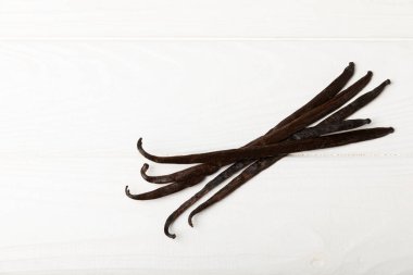 Dokulu bir arka planda vanilya kabukları. Vanilya çiçekleri ve tohumlar. Vanilyalı fasulye. Hamur işleri ve tatlılar için baharatlı baharat. Baharat. Mesaj için yer var. Boşluğu Kopyala