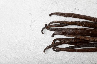 Dokulu bir arka planda vanilya kabukları. Vanilya çiçekleri ve tohumlar. Vanilyalı fasulye. Hamur işleri ve tatlılar için baharatlı baharat. Baharat. Mesaj için yer var. Boşluğu Kopyala