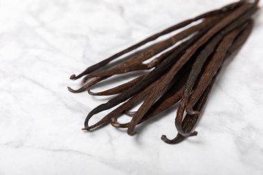 Dokulu bir arka planda vanilya kabukları. Vanilya çiçekleri ve tohumlar. Vanilyalı fasulye. Hamur işleri ve tatlılar için baharatlı baharat. Baharat. Mesaj için yer var. Boşluğu Kopyala