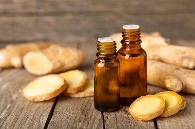  Doku arka planında zencefil yağı var. Taze zencefil dilimleri. Esans, serum, yağ. Alternatif tıp. Beden eğitimi. Sağlık ve güzellik konsepti. Mesaj için yer. Boşluğu kopyala.