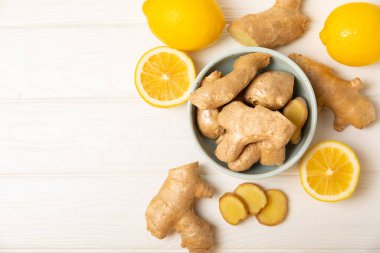 Ahşap arka planda taze zencefil. Kuru zencefil. Ballı ve limonlu zencefil dilimi. Zencefil kökü. Geleneksel alternatif tıp, bağışıklık için çay. Baharat ve baharat konsepti. Boşluğu kopyala.