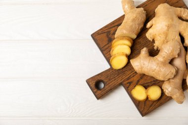 Ahşap arka planda taze zencefil. Kuru zencefil. Ballı ve limonlu zencefil dilimi. Zencefil kökü. Geleneksel alternatif tıp, bağışıklık için çay. Baharat ve baharat konsepti. Boşluğu kopyala.