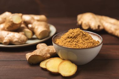 Ahşap arka planda taze zencefil. Kuru zencefil. Ballı ve limonlu zencefil dilimi. Zencefil kökü. Geleneksel alternatif tıp, bağışıklık için çay. Baharat ve baharat konsepti. Boşluğu kopyala.
