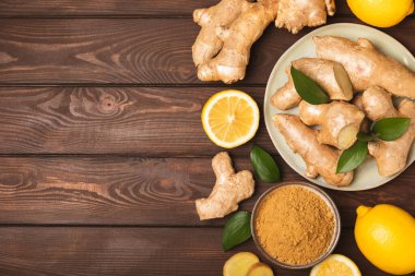 Ahşap arka planda taze zencefil. Kuru zencefil. Ballı ve limonlu zencefil dilimi. Zencefil kökü. Geleneksel alternatif tıp, bağışıklık için çay. Baharat ve baharat konsepti. Boşluğu kopyala.