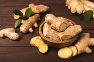 Ahşap arka planda taze zencefil. Kuru zencefil. Ballı ve limonlu zencefil dilimi. Zencefil kökü. Geleneksel alternatif tıp, bağışıklık için çay. Baharat ve baharat konsepti. Boşluğu kopyala.