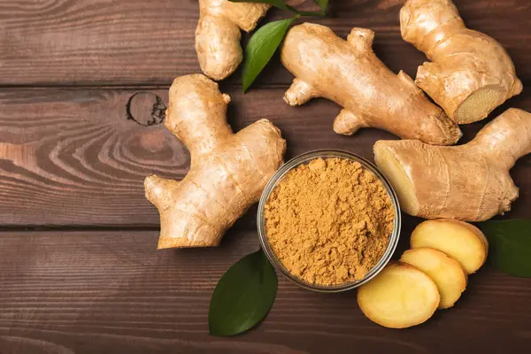 Ahşap arka planda taze zencefil. Kuru zencefil. Ballı ve limonlu zencefil dilimi. Zencefil kökü. Geleneksel alternatif tıp, bağışıklık için çay. Baharat ve baharat konsepti. Boşluğu kopyala.
