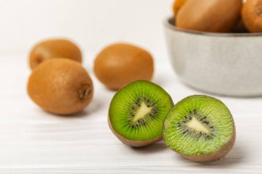 Ahşap arka planda Kivi. Masada tam meyve ve dilimler halinde yeşil kivi var. Taze sulu kivi. Tropik meyve. Organik meyve. Sağlıklı beslenme. Mesaj için yer var. Boşluğu kopyala.