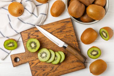 Ahşap arka planda Kivi. Masada tam meyve ve dilimler halinde yeşil kivi var. Taze sulu kivi. Tropik meyve. Organik meyve. Sağlıklı beslenme. Mesaj için yer var. Boşluğu kopyala.