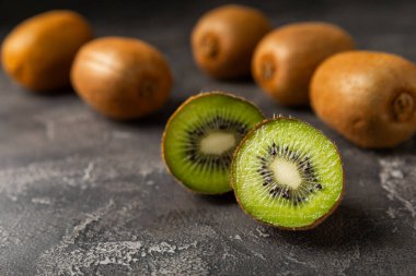 Ahşap arka planda Kivi. Masada tam meyve ve dilimler halinde yeşil kivi var. Taze sulu kivi. Tropik meyve. Organik meyve. Sağlıklı beslenme. Mesaj için yer var. Boşluğu kopyala.