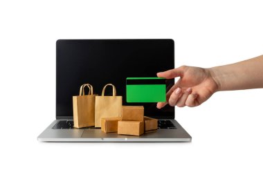 Çevrimiçi alışveriş kavramı. Karton kutu ve alışveriş poşetleri beyaz arka planda izole edilmiş bir tramvayda. Alışveriş sepeti. İnternetten bilgisayar, tablet, telefon ve kredi kartı kullanarak alışveriş. Eve teslim.