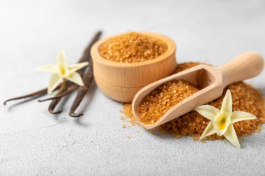 Aromatik vanilya şekeri. Vanilya kabukları. Vanilya çubukları, esmer ve beyaz şeker dokulu arka planda bir kasede. Vanilya çiçekleri, baharatlar ve tatlı ve pişirme için bitkiler. Mesaj için yer var. Boşluğu kopyala