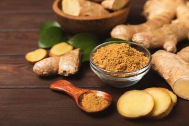 Ahşap arka planda taze zencefil. Kuru zencefil. Ballı ve limonlu zencefil dilimi. Zencefil kökü. Geleneksel alternatif tıp, bağışıklık için çay. Baharat ve baharat konsepti. Boşluğu kopyala.