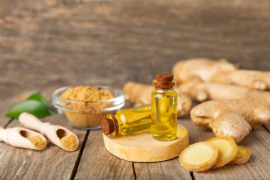 Doku arka planında zencefil yağı var. Taze zencefil dilimleri. Esans, serum, yağ. Alternatif tıp. Beden eğitimi. Sağlık ve güzellik konsepti. Mesaj için yer. Boşluğu kopyala.