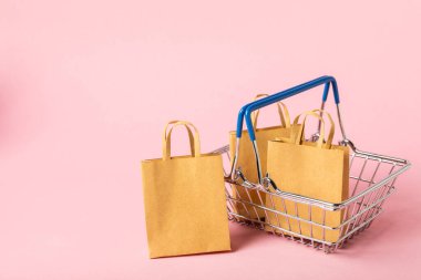 Çevrimiçi alışveriş kavramı. Karton kutu ve parlak renkli bir arka planda tramvayda alışveriş poşetleri. Alışveriş sepeti. İnternetten bilgisayar, tablet, telefon ve kredi kartı kullanarak alışveriş. Eve teslim.