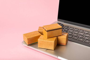 Çevrimiçi alışveriş kavramı. Karton kutu ve parlak renkli bir arka planda tramvayda alışveriş poşetleri. Alışveriş sepeti. İnternetten bilgisayar, tablet, telefon ve kredi kartı kullanarak alışveriş. Eve teslim.
