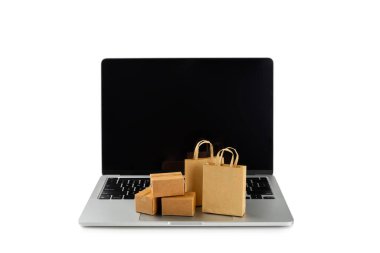 Çevrimiçi alışveriş kavramı. Karton kutu ve alışveriş poşetleri beyaz arka planda izole edilmiş bir tramvayda. Alışveriş sepeti. İnternetten bilgisayar, tablet, telefon ve kredi kartı kullanarak alışveriş. Eve teslim.