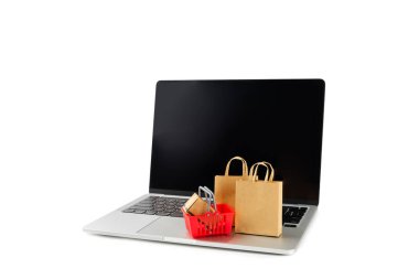 Çevrimiçi alışveriş kavramı. Karton kutu ve alışveriş poşetleri beyaz arka planda izole edilmiş bir tramvayda. Alışveriş sepeti. İnternetten bilgisayar, tablet, telefon ve kredi kartı kullanarak alışveriş. Eve teslim.