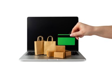 Çevrimiçi alışveriş kavramı. Karton kutu ve alışveriş poşetleri beyaz arka planda izole edilmiş bir tramvayda. Alışveriş sepeti. İnternetten bilgisayar, tablet, telefon ve kredi kartı kullanarak alışveriş. Eve teslim.