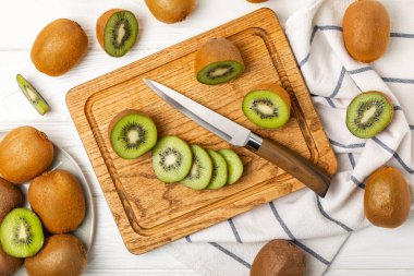 Ahşap arka planda Kivi. Masada tam meyve ve dilimler halinde yeşil kivi var. Taze sulu kivi. Tropik meyve. Organik meyve. Sağlıklı beslenme. Mesaj için yer var. Boşluğu kopyala