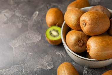 Ahşap arka planda Kivi. Masada tam meyve ve dilimler halinde yeşil kivi var. Taze sulu kivi. Tropik meyve. Organik meyve. Sağlıklı beslenme. Mesaj için yer var. Boşluğu kopyala