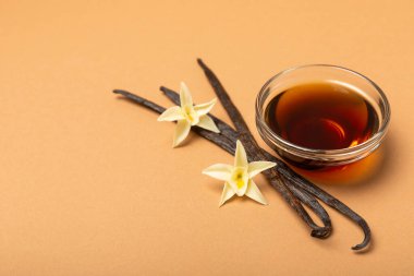 Tahta bir masanın üzerinde cam kaplama vanilya özü. Kek ve tatlı için vanilya özü. Aromatik ev yapımı vanilya özü. Kapatın. Mesajı yerleştir. Boşluğu kopyala.