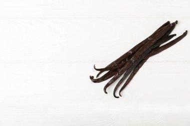 Dokulu bir arka planda vanilya kabukları. Vanilya çiçekleri ve tohumlar. Vanilyalı fasulye. Hamur işleri ve tatlılar için baharatlı baharat. Baharat. Mesaj için yer var. Boşluğu Kopyala