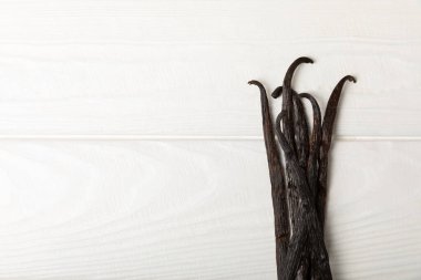 Dokulu bir arka planda vanilya kabukları. Vanilya çiçekleri ve tohumlar. Vanilyalı fasulye. Hamur işleri ve tatlılar için baharatlı baharat. Baharat. Mesaj için yer var. Boşluğu Kopyala