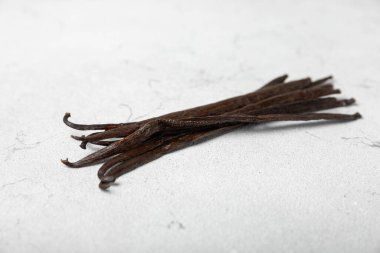 Dokulu bir arka planda vanilya kabukları. Vanilya çiçekleri ve tohumlar. Vanilyalı fasulye. Hamur işleri ve tatlılar için baharatlı baharat. Baharat. Mesaj için yer var. Boşluğu Kopyala