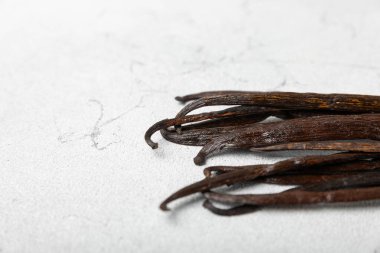 Dokulu bir arka planda vanilya kabukları. Vanilya çiçekleri ve tohumlar. Vanilyalı fasulye. Hamur işleri ve tatlılar için baharatlı baharat. Baharat. Mesaj için yer var. Boşluğu Kopyala