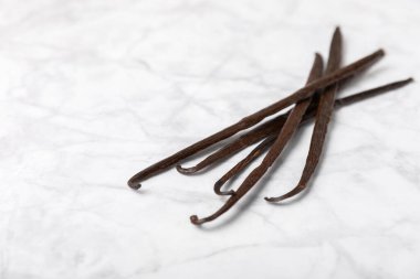 Dokulu bir arka planda vanilya kabukları. Vanilya çiçekleri ve tohumlar. Vanilyalı fasulye. Hamur işleri ve tatlılar için baharatlı baharat. Baharat. Mesaj için yer var. Boşluğu Kopyala