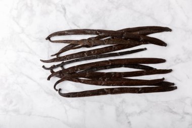 Dokulu bir arka planda vanilya kabukları. Vanilya çiçekleri ve tohumlar. Vanilyalı fasulye. Hamur işleri ve tatlılar için baharatlı baharat. Baharat. Mesaj için yer var. Boşluğu Kopyala