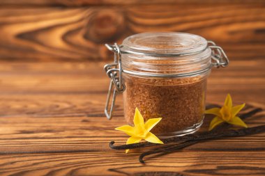 Aromatik vanilya şekeri. Vanilya kabukları. Vanilya çubukları, esmer ve beyaz şeker dokulu arka planda bir kasede. Vanilya çiçekleri, baharatlar ve tatlı ve pişirme için bitkiler. Mesaj için yer var. Boşluğu kopyala