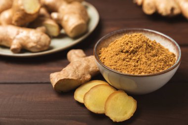 Ahşap arka planda taze zencefil. Kuru zencefil. Ballı ve limonlu zencefil dilimi. Zencefil kökü. Geleneksel alternatif tıp, bağışıklık için çay. Baharat ve baharat konsepti. Boşluğu kopyala.