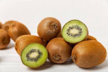 Ahşap arka planda Kivi. Masada tam meyve ve dilimler halinde yeşil kivi var. Taze sulu kivi. Tropik meyve. Organik meyve. Sağlıklı beslenme. Mesaj için yer var. Boşluğu kopyala