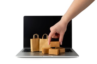 Çevrimiçi alışveriş kavramı. Karton kutu ve alışveriş poşetleri beyaz arka planda izole edilmiş bir tramvayda. Alışveriş sepeti. İnternetten bilgisayar, tablet, telefon ve kredi kartı kullanarak alışveriş. Eve teslim.