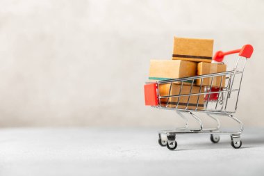 Çevrimiçi alışveriş kavramı. Karton kutu ve parlak renkli bir arka planda tramvayda alışveriş poşetleri. Alışveriş sepeti. İnternetten bilgisayar, tablet, telefon ve kredi kartı kullanarak alışveriş. Eve teslim.