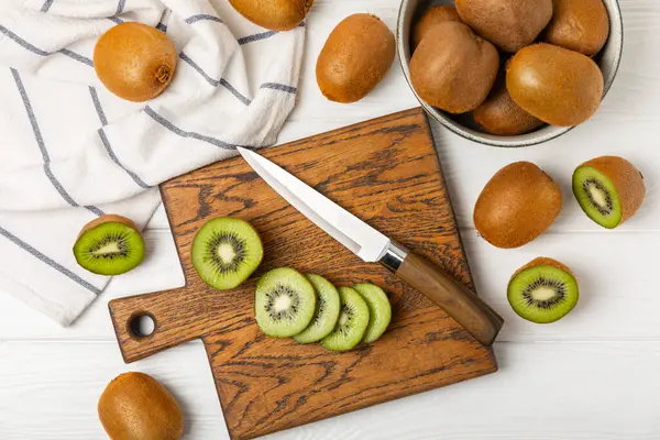 Ahşap arka planda Kivi. Masada tam meyve ve dilimler halinde yeşil kivi var. Taze sulu kivi. Tropik meyve. Organik meyve. Sağlıklı beslenme. Mesaj için yer var. Boşluğu kopyala