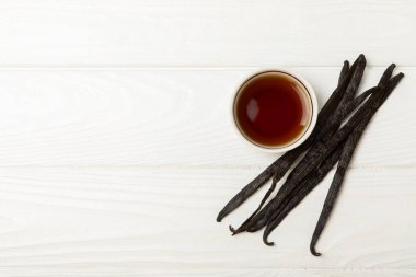 Tahta bir masanın üzerinde cam kaplama vanilya özü. Kek ve tatlı için vanilya özü. Aromatik ev yapımı vanilya özü. Kapatın. Mesajı yerleştir. Boşluğu kopyala.